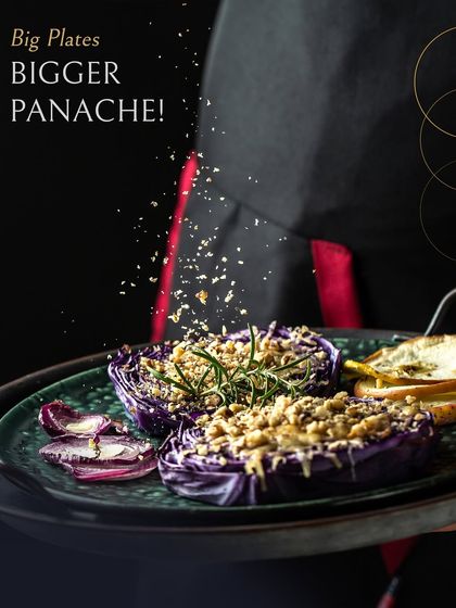 Big plates, bigger panache. This dish features roasted purple cabbage halves, generously topped with a crunchy crumble and fresh rosemary, served by one of our chefs. It's a testament to how we can transform simple ingredients into a gourmet experience.