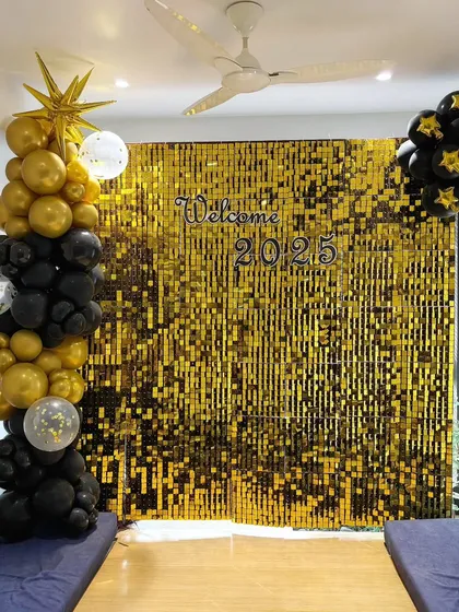 Getting ready for New Year's Eve? We created this 'Welcome 2025' party backdrop using a gold shimmer wall with black and gold balloon pillars for a festive and glamorous celebration.