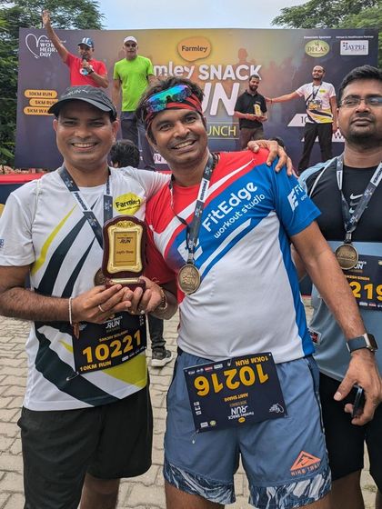 Two runners celebrating a podium finish with their trophy. We recognize and award top performers in various categories.