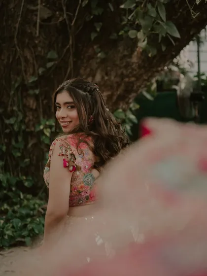 A candid, over-the-shoulder glance from the bride. Her smile is infectious, and this shot captures her playful and happy spirit during the Haldi ceremony.