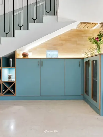 A clever use of under-stair space, transformed into a stylish bar area with a built-in wine rack and blue cabinetry. The backlighting adds a sophisticated glow to this functional and attractive feature.