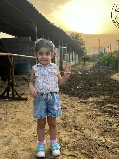 A happy child poses near the stables at sunset, capturing the calm and beautiful atmosphere of the club.