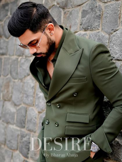 A moment of quiet contemplation in the olive green suit. The double-breasted design and wide lapels create a look of timeless power and sophistication.