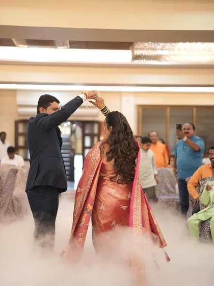 A magical first dance at the reception. The bride's flowing pink saree and elegant hairstyle look beautiful in motion.