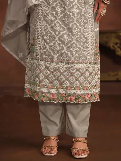 A graceful grey salwar kameez with delicate floral and geometric thread embroidery. The organza fabric and detailed hem on the pants and dupatta add a touch of luxury.