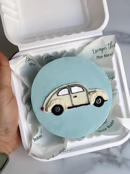 A cute buttercream mini featuring a doodle of a vintage beetle car. These mini cakes are a great way to sample flavors before ordering a larger cake for a big occasion.