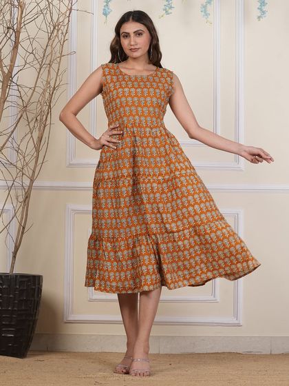 A model shot of the mustard yellow tiered dress, showing how the skirt flows with movement.