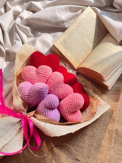 A beautiful shot of the heart bouquet, styled with an open book. The different shades of pink and red create a lovely ombre effect, making it a truly romantic gift.
