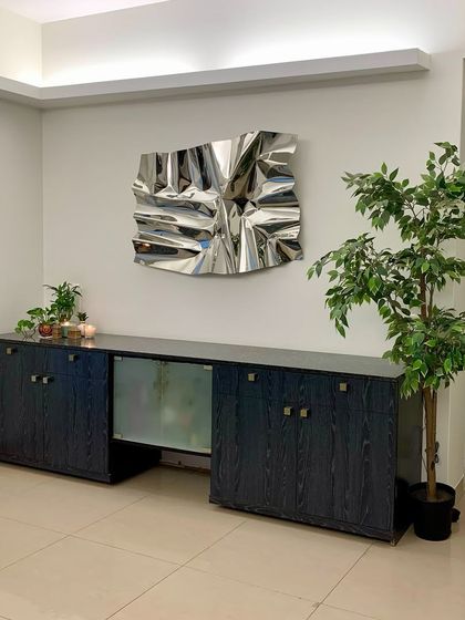 The reflective surface of this silver Meteor piece brightens the corner of the room and interacts with the surrounding plants and decor.