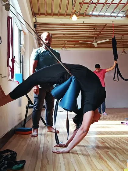 This image shows the full extension possible when using wall ropes for backbends. It helps to create space between the vertebrae and improve posture.