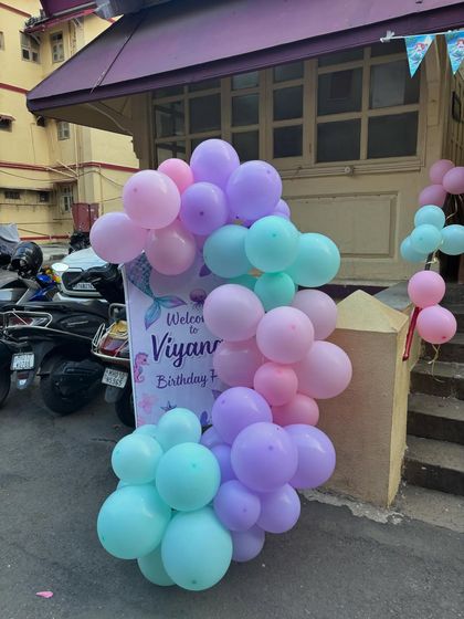 The welcome sign and balloon arrangement at the entrance, inviting guests into Viyana's magical mermaid party with a coordinated color palette.