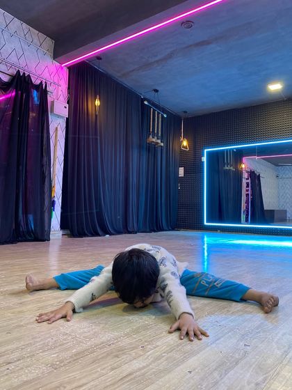 A young student works on his middle splits, a key flexibility skill. We guide students through these stretches safely to increase their range of motion over time.