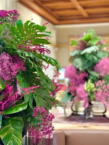 A focused shot showing the two complementary pink and green arrangements in the lobby. Creating a cohesive visual language across the space ensures a harmonious and impactful design.