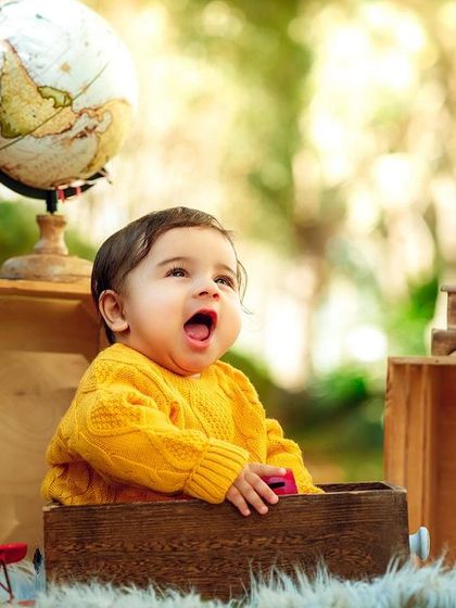 A little traveler exploring the world. This outdoor setup with a globe, vintage phone, and gramophone sparks the imagination.