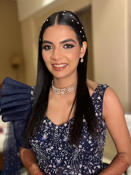 The complete reception look, featuring a modern, sleek hairstyle with pearl details that adds a touch of elegance to the dramatic makeup.