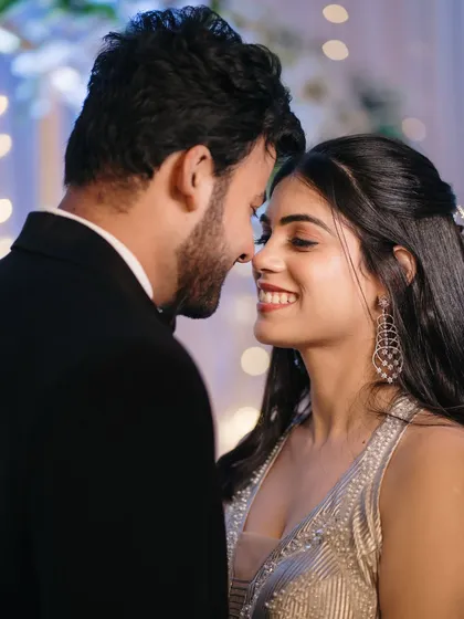 An intimate close-up, nose-to-nose, capturing the happy smiles and excitement of the newly engaged couple under soft party lighting.