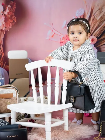 Posing with her designer bag, this little one is ready for the runway. A fun and unique theme for a very fashionable baby.