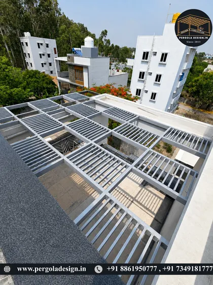 This high-angle shot showcases the expansive coverage of the louvered rooftop pergola. The design creates interesting shadow patterns while effectively protecting the space below from direct sunlight.