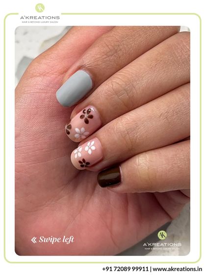 A close-up of the delicate brown and white floral nail art, highlighting the fine details and the contrast with the matte grey accent nail.