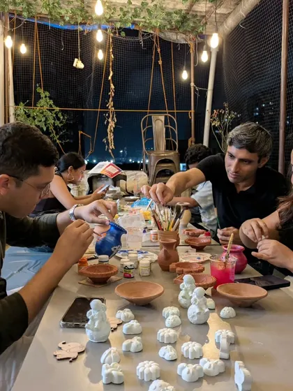 Imagine your team unwinding like this. This shot captures the relaxed atmosphere of a pottery painting session at my studio, under the warm glow of string lights.