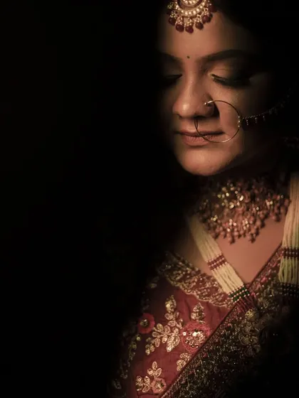 An intense, low-key bridal portrait. The dramatic shadows and her serene expression create a powerful and artistic image.