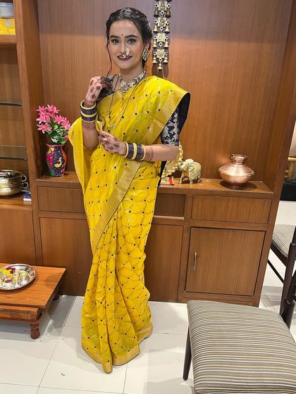 A royal look for a special event. The client is wearing a stunning yellow Raw Mango saree with a traditional Maharashtrian nath.