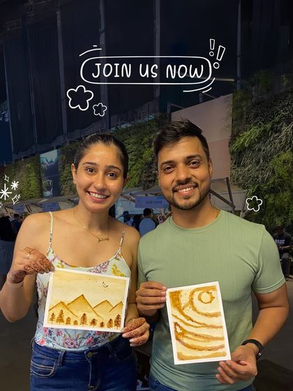 A happy couple proudly displays the coffee paintings they created together. An art date is a chance to try something new and leave with a unique piece of your shared experience.
