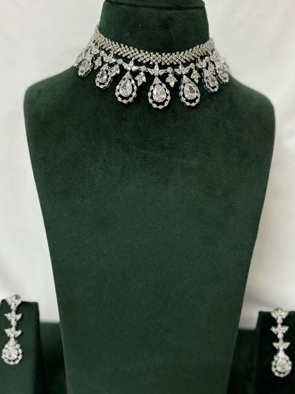 A simple American diamond necklace with matching earrings. This is a versatile rental set that can be worn for various occasions.