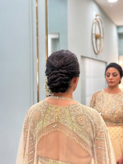 A clean and elegant twisted low bun. This sophisticated updo is perfect for the mother of the bride or for a formal event.