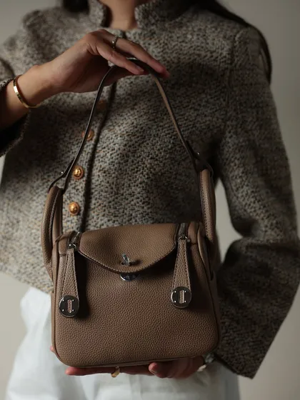 A close up of me holding the Linde Medium bag. You can really see the quality of the pebbled leather and the classic turn-lock clasp in this shot.