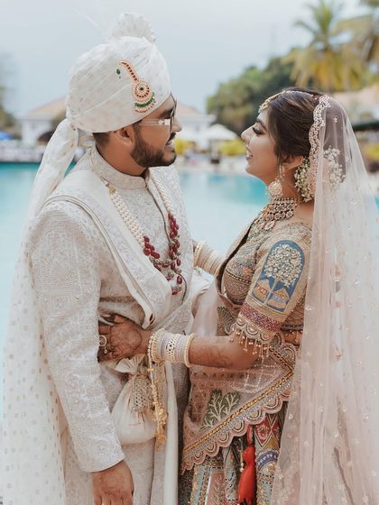 A lovely couple portrait by the pool. Mahima's pastel look coordinates beautifully with the serene blue background and her groom's attire.