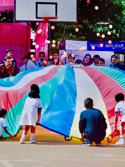 A giant parachute becomes the centerpiece of a school sports day event. These large-scale group activities are perfect for getting the entire school involved and creating lasting, happy memories.