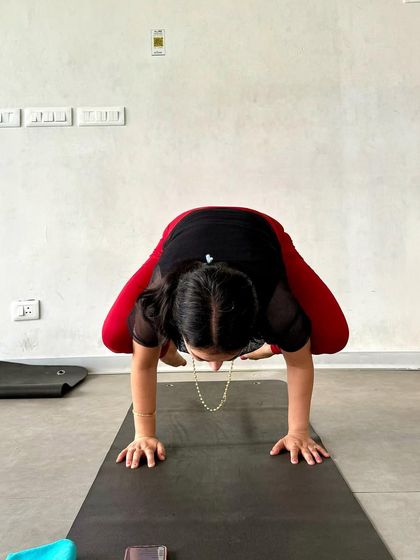 A front view of Bakasana (Crow Pose). This arm balance requires core strength, concentration, and a willingness to play with your balance.