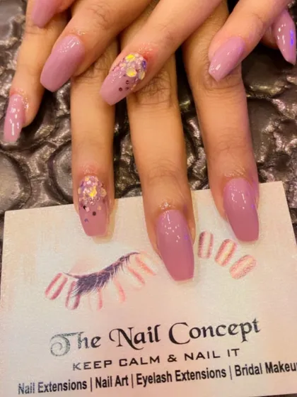 A soft mauve color on coffin-shaped nails. The accent nails feature a fun, chunky multi-colored glitter for a playful pop of sparkle.