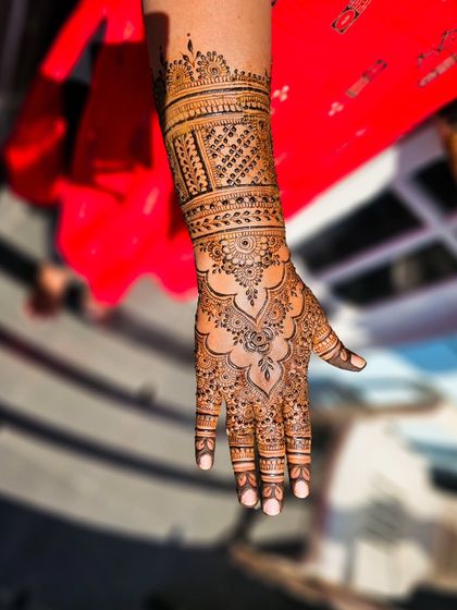 A single arm shot of a beautiful bridal design, with a focus on the intricate palm work.