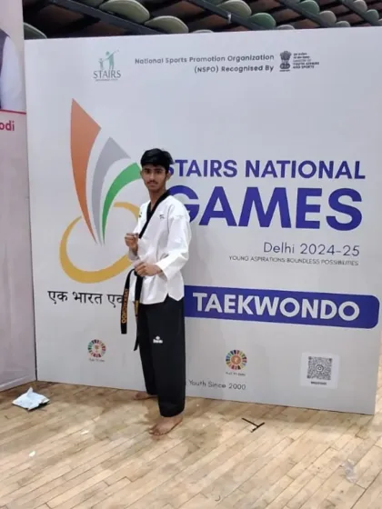A black belt student posing confidently at the Stairs National Games. Competing at this level builds immense confidence and experience.
