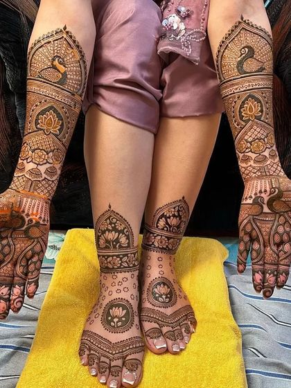 A complete bridal set, this photo shows the intricate hand mehndi along with the matching lotus and peacock designs on the feet.