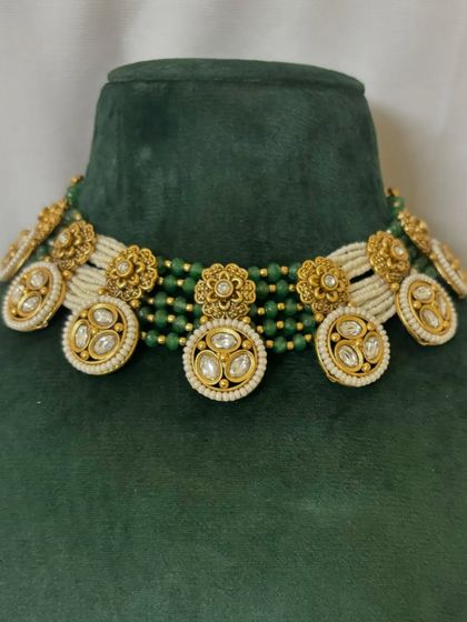 A unique choker design with floral motifs and Kundan work, set on a base of green and white beads. This piece is available for rent in Mumbai.