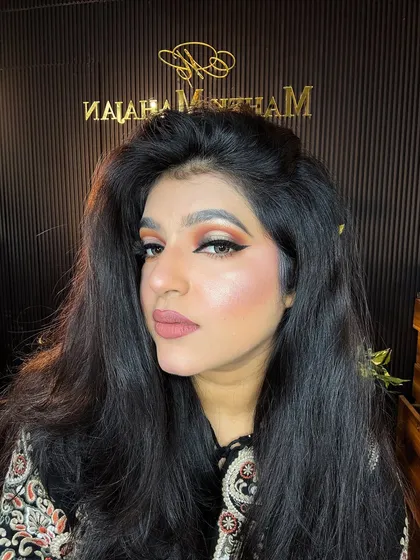 A self-portrait showing a classic winged liner with a warm, orange-toned eyeshadow. This is a versatile look for many occasions.