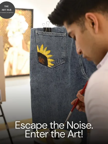 Escape the noise and enter the world of art. This student is personalizing a pair of jeans with a painted sunflower, showing how art can be applied to everyday items.