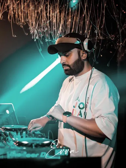 A cool, calm, and collected moment at the DJ booth. The teal lighting adds to the modern, stylish vibe of the event.