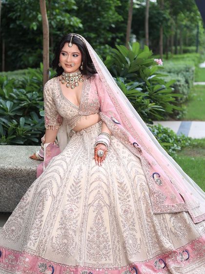 A full view of the bride in her stunning pastel lehenga. The intricate silver work and the peacock motifs on the border are simply breathtaking.