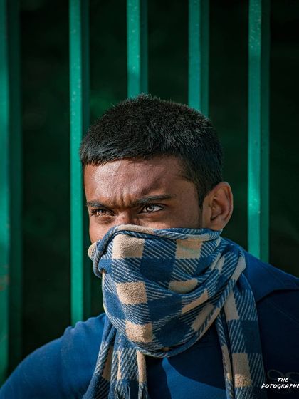 Even when a face is partially covered, the eyes can tell a powerful story. This portrait of a migrant worker has an intensity that comes purely from his sharp, focused gaze.
