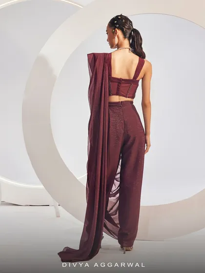 The back view of the Isla Saree Set in maroon, showcasing the unique dhoti-style drape and the delicate straps of the corset blouse.