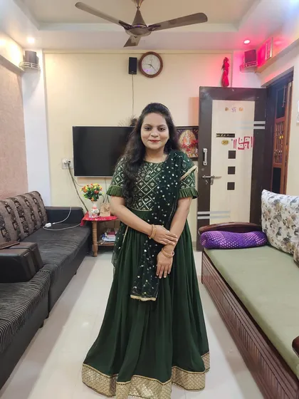 A client looking lovely in a dark green lehenga choli I designed. The outfit features a detailed blouse and a flowing skirt with a golden border, perfect for festive occasions like Diwali.