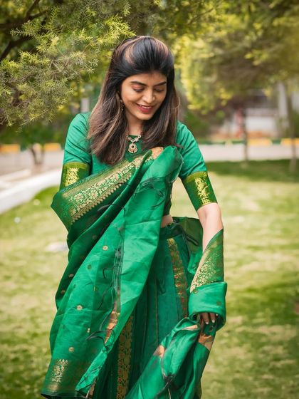 A candid moment showing the beautiful details of the green saree. I focus on capturing the fabric, colors, and accessories of traditional wear.