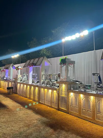 This is a look at one of my full-scale outdoor buffet setups. I use custom-built counters with elegant carvings and warm lighting to create a grand and inviting dining experience that complements the celebration, no matter the size of your guest list.