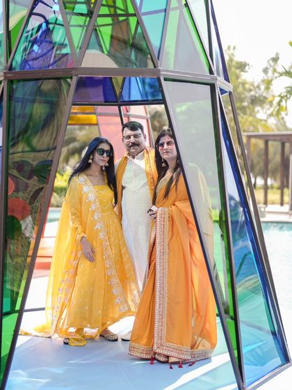 Guests posing inside one of the smaller, human-sized acrylic towers at the Coachella Haldi. These structures provided fantastic photo opportunities.