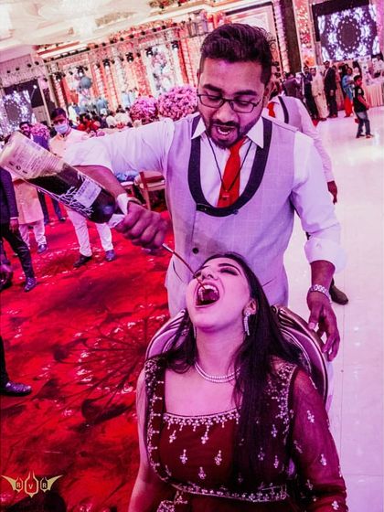 Let's get ready to stumble. A guest enjoys a drink poured straight from the bottle by one of our energetic bartenders during a wedding reception.