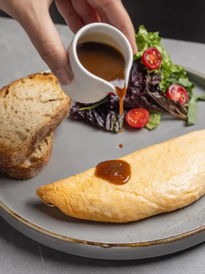The Braised Lamb Omelette is pure comfort. I fill soft folds of egg with tender, slow-cooked pulled lamb and sharp goat's cheese, then finish it with a red wine lamb jus.